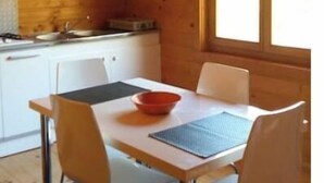 Una cocina compacta con armarios blancos y un ventanal sobre el fregadero.