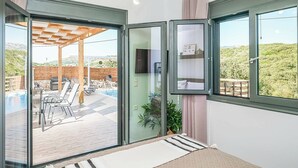 Ein modernes Zimmer mit einer Schiebetür zu einer Außenpatio mit Pool und Sitzgelegenheit.