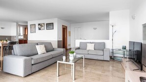 A modern living room with two grey sofas, a glass coffee table, and a TV on a wooden stand. - Villa Rachel - Three Bedroom Villa, Sleeps 6 (Es Mercadal)