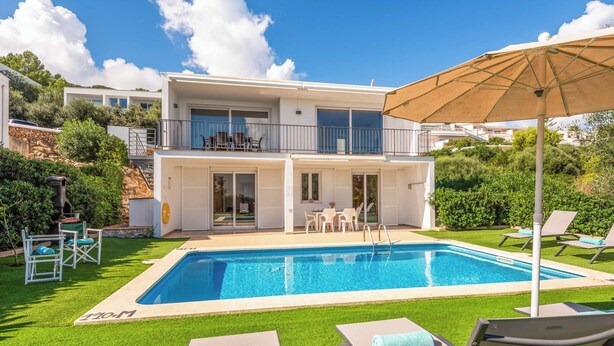 A two-story house with a swimming pool, outdoor furniture, and a balcony. - Villa Rachel - Three Bedroom Villa, Sleeps 6 (Es Mercadal)