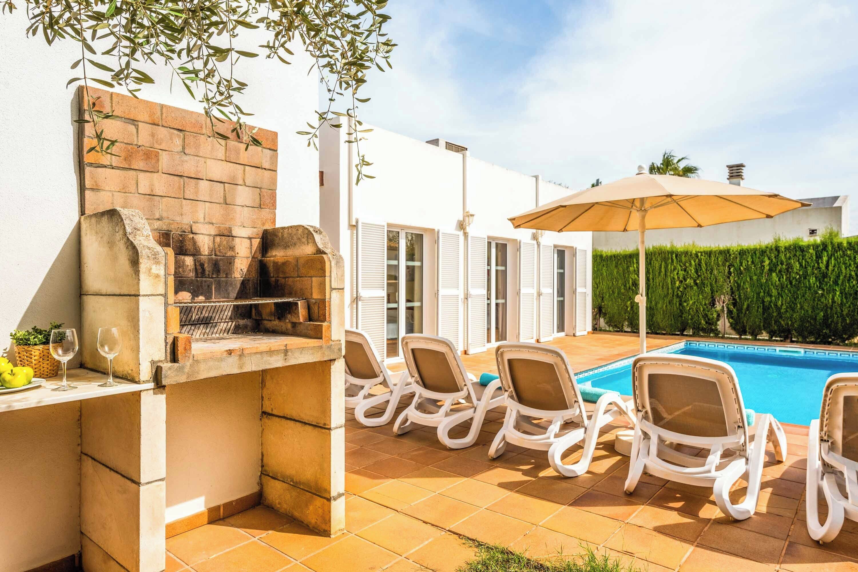 Een terras met een barbecue, lounge stoelen en een zwembad.