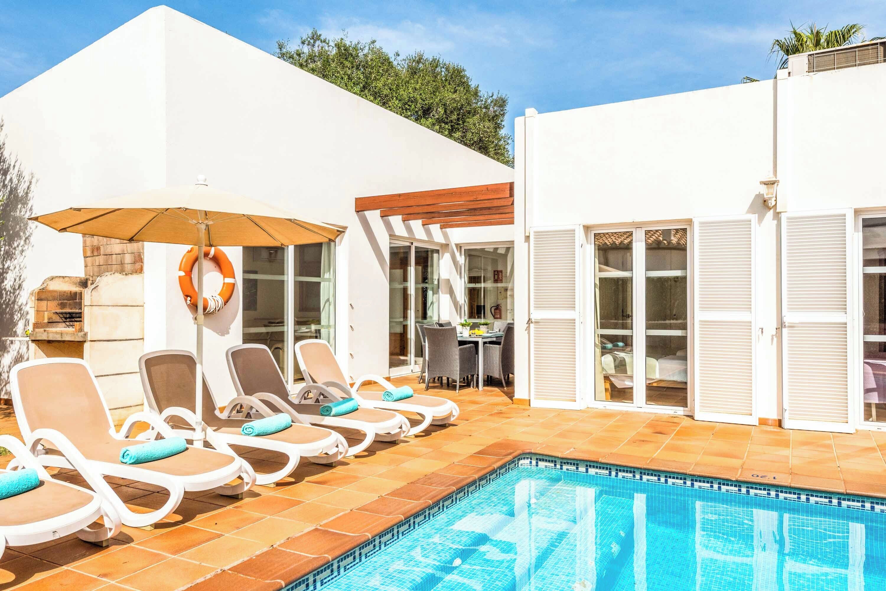 Zona de piscina con sillones de descanso y una pileta.