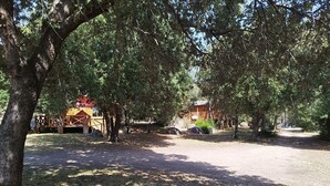 A campground with picnic tables, a covered picnic area, and a small cabin. - La Tinutella 4, la tinutella (Olmeto)