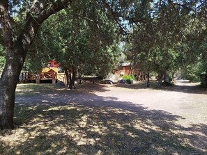 A campground with picnic tables, a covered picnic area, and a small cabin.
