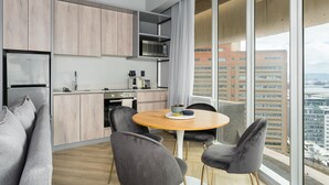 Eine moderne Küche mit Holzschränken, einer Mikrowelle und einem Essbereich mit rundem Tisch und Stühlen.