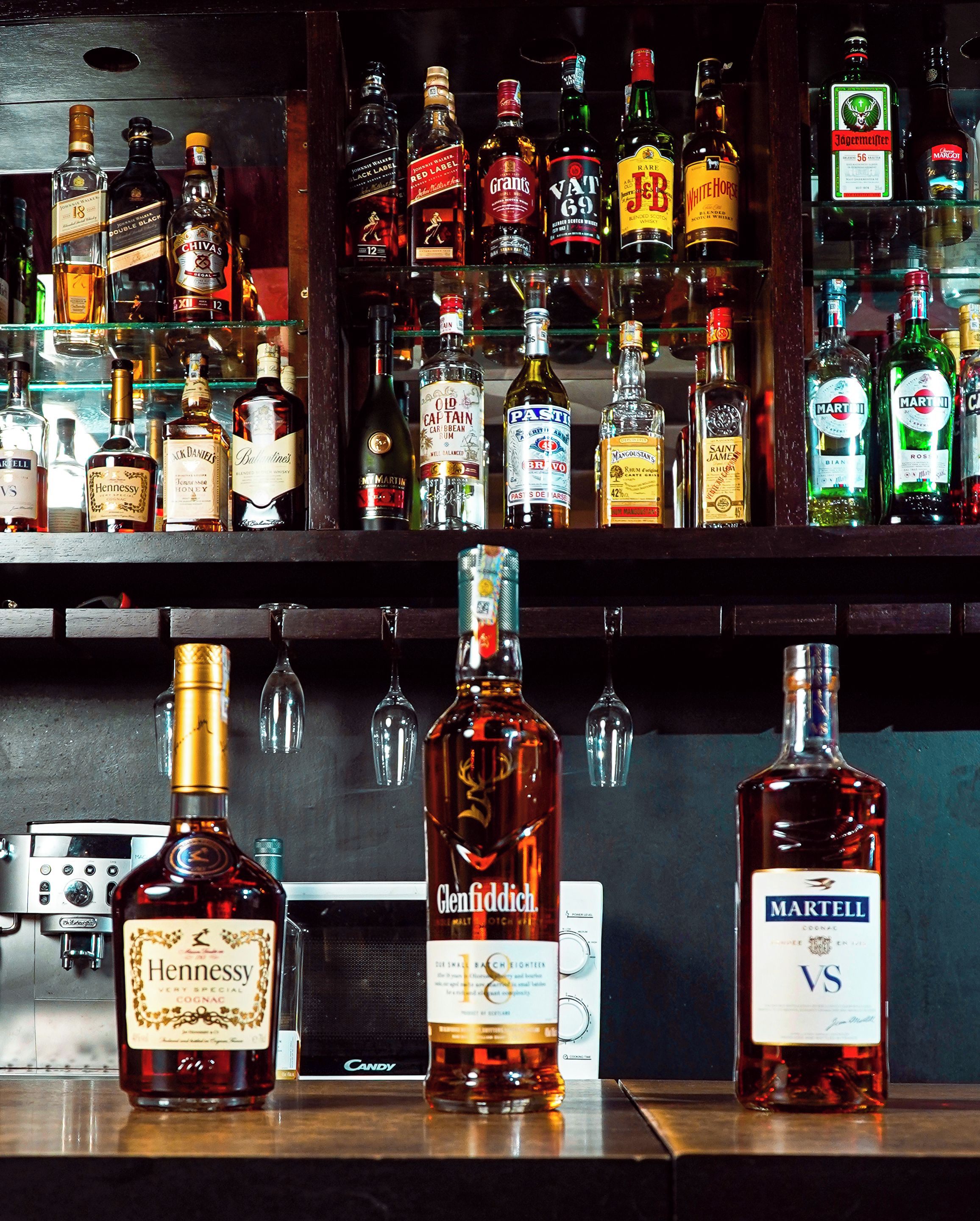 En bar med diverse flasker alkohol, hvor en whiskeyflaske er i fokus.