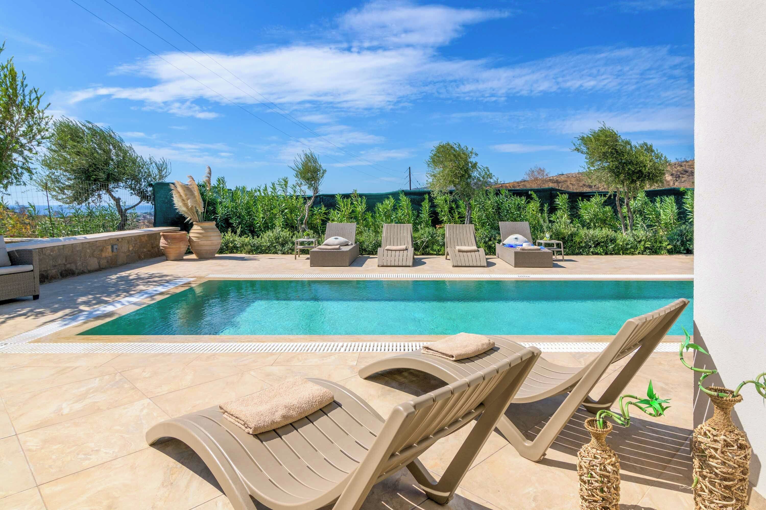 A pool area with lounge chairs and potted plants.
