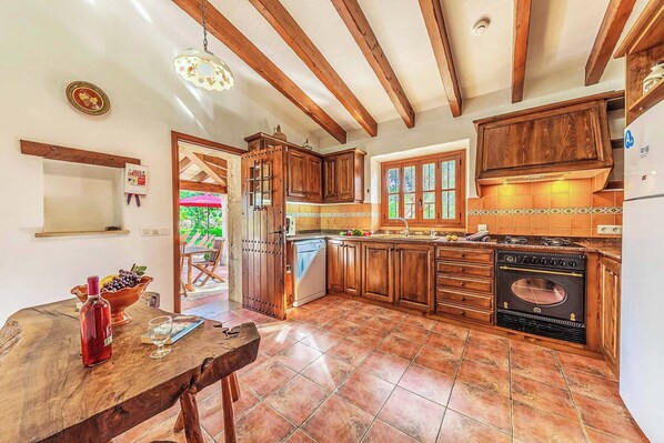 A kitchen with wooden cabinets, a built-in oven, and a tiled floor.