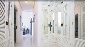 A hallway with white doors and a tiled floor.
