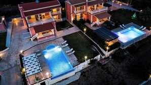 A two-story house with a swimming pool, outdoor seating, and a well-lit garden. - Villa Mirela Mikri - Three Bedroom Villa, Sleeps 6 (Corfu)