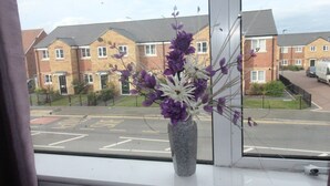A window with a vase of purple flowers. - Doe Quarry (Sheffield)