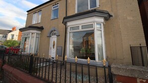 A two-story house with a bay window, a small porch, and a black metal fence. - Doe Quarry (Sheffield)