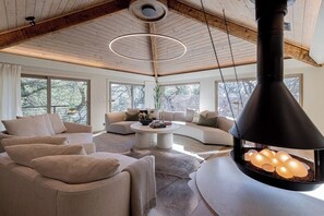 A modern living room with a large fireplace, a sofa set, and a coffee table.