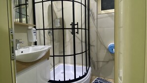 Une salle de bain moderne avec une douche à parois de verre, un lavabo et un tapis à motifs bleus sur le sol.