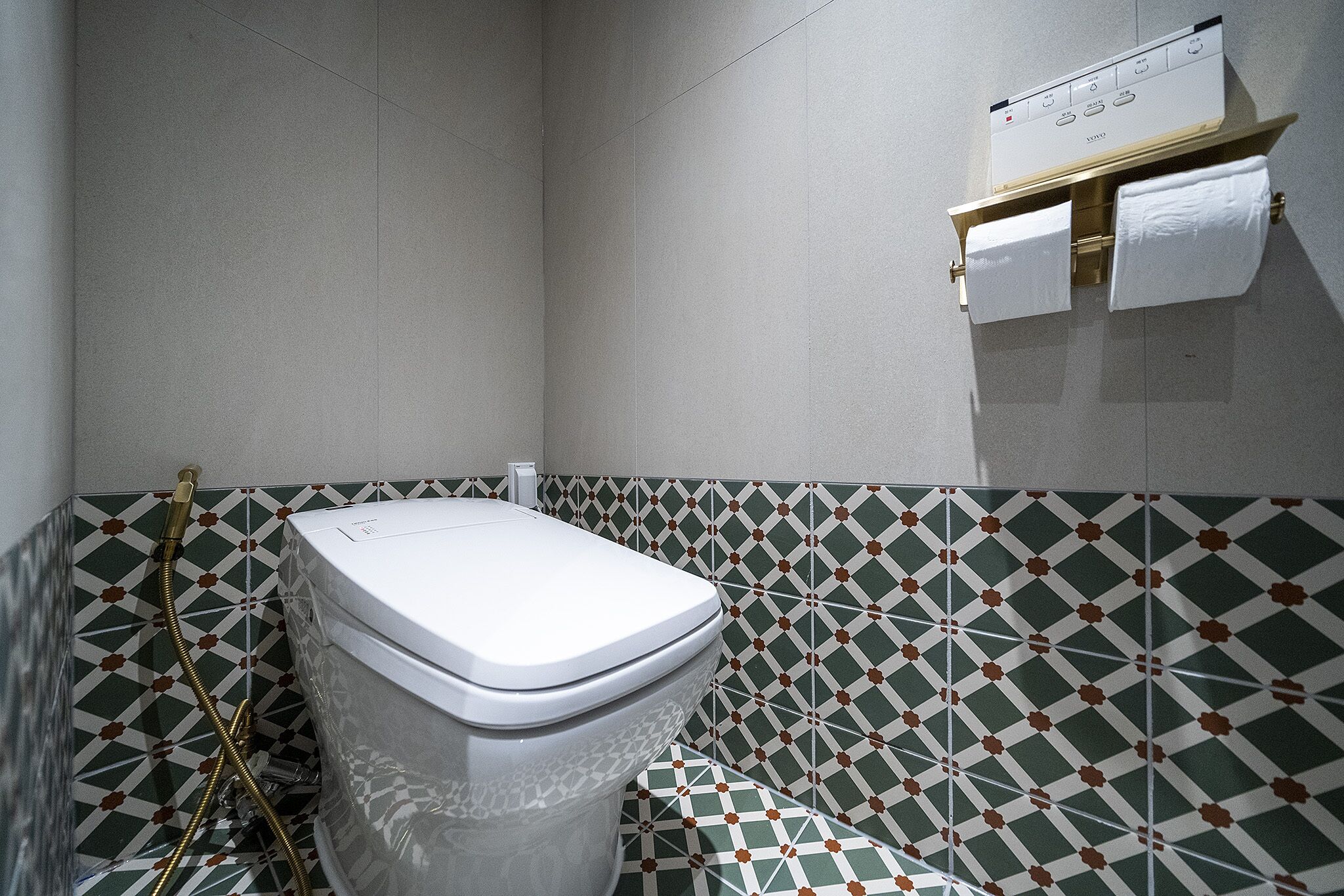 Un baño con inodoro, ducha y toallero.