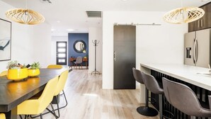 A modern kitchen with a central island, yellow chairs, and pendant lights. - Retro Mid-Mod Vibes Getaway (Centrally Located) (Phoenix)