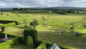 A well-maintained lawn with a few trees and a hedge in the foreground. - FeWo Siebenstern Fernblick am Hohen Venn (Monschau)
