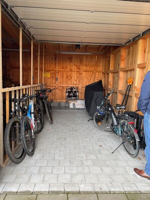A covered bicycle storage area with wooden walls and a tiled floor. - FeWo Siebenstern Fernblick am Hohen Venn (Monschau)