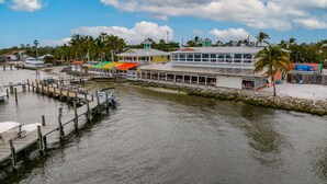 A waterfront property with a dock, a restaurant with outdoor seating, and a view of the water. - New and sparkly 2/1 on 4 acres! (Sebastian)
