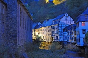 Une ville historique, avec ses bâtiments traditionnels à colombages, qui s’étend le long d’une rivière.