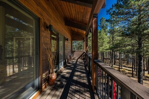 A wooden deck with a railing, a potted plant, and a staircase leading to a covered area. - Beautiful, Huge Home on Golf Course and close to Ski Resort. Recently Renovated! (Angel Fire)