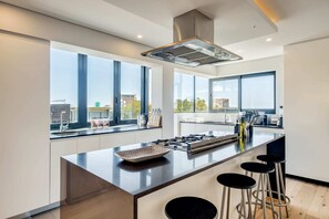 Enjoy cooking in this well-equipped kitchen with a central island, gas stove, and stainless steel range hood.