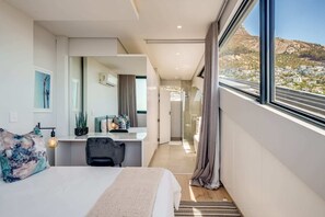 Relax in a serene space with a large bed, desk, and stunning mountain views.