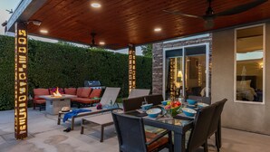 An outdoor patio with a dining table, chairs, and a fire pit. - Veranda Aqua – Colorful Palm Springs Retreat (Palm Springs)