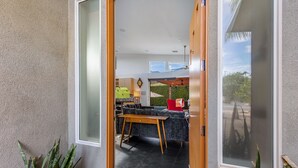 A modern interior with a dining area, a kitchen, and a view of the outdoors. - Veranda Aqua – Colorful Palm Springs Retreat (Palm Springs)