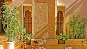 A spa area with a hot tub, potted plants, and a red carpet. - Riad Flam & Spa (Marrakech)