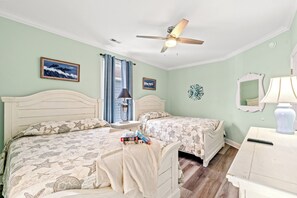 A bedroom with two beds, a ceiling fan, a nightstand with a lamp, and a dresser. - Just Coasting - Saltwater Pool, 5 Bedrooms, Across Street to Beach (North Myrtle Beach)