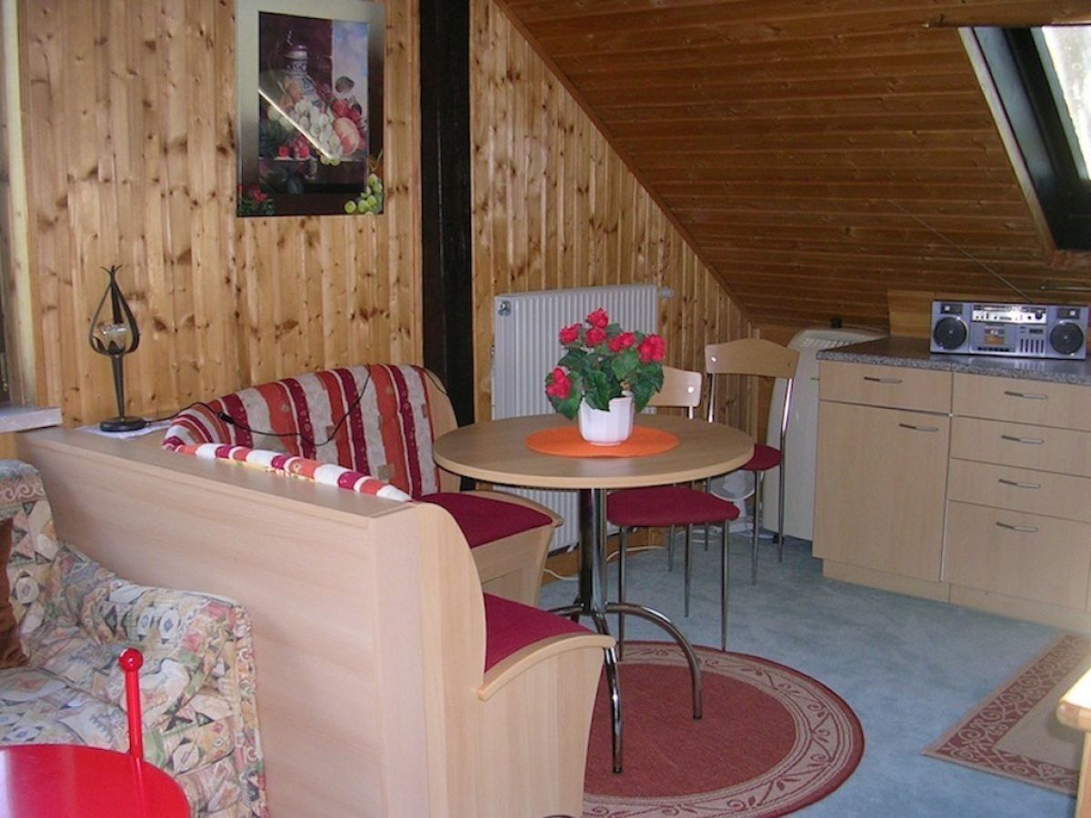 Ein gemütlicher Holzraum mit Essbereich, einer Couch und einer Küche.