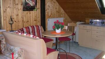 Ein gemütlicher Holzraum mit Essbereich, einer Couch und einer Küche.