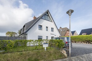 A white building with a sloped roof and multiple windows, labeled "Ringhoog Huis 19".