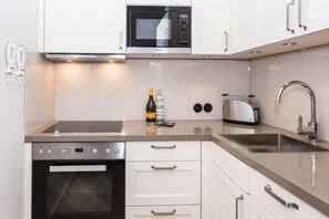 A modern kitchen with a built-in oven, microwave, and toaster.