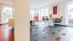 A modern kitchen with a dining area, large windows, and a television. - Hell. Entspannend. Komfortabel (Westerland)