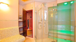 Une salle de bain moderne avec une douche à parois de verre, un banc et un sol carrelé.