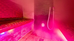 Un baño de vapor con un banco de azulejos y una zona de ducha.
