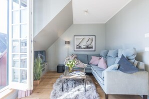 A cozy living room with a sofa, a coffee table, and a framed picture on the wall.