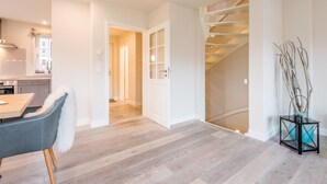 Et moderne interiør med spiseplads, trappe og køkken.