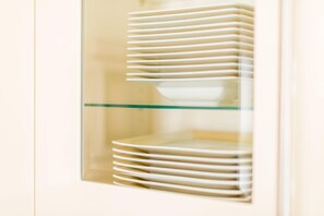 A stack of white plates inside a glass-fronted cabinet. - Wellness. Sauna. Strandnah. Residenz Bismarck, Whg. 3 Objekt-id: Hrb/03 (Westerland)