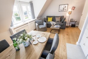 A modern loft apartment with a dining area, a sofa set, and a floor lamp.