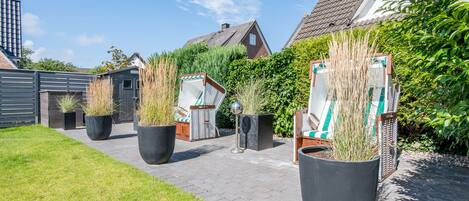 A garden pathway with potted plants and outdoor furniture.