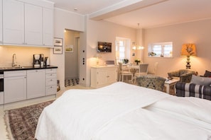 Un dormitorio moderno con una cama grande, un escritorio y un rincón comedor.