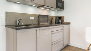 Eine moderne Küche mit zwei Spülen, Edelstahlgeräten und einem eingebauten Backofen.