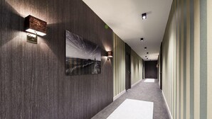 A hallway with dark wood paneling, a large framed picture, and a carpeted floor. - Modern. Apart. Lichtdurchflutet. Neue Mitte, Whg. 4 Objekt-id: Nmw/04 (Westerland)
