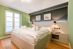 Ein Schlafzimmer mit einem großen Bett, Nachttischen und einem Fenster.