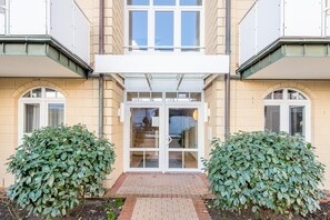 A building with a double door entrance, two symmetrical side windows, and a brick pathway leading to the entrance. - Residence Bismarck, Whg. 5a (Westerland)