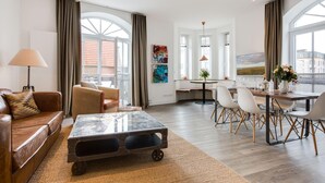 A spacious living area with a sofa, coffee table, and dining table set with chairs. - Ausblick. Komfortabel. Südbalkon (Westerland)