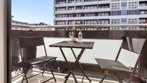 A balcony with two chairs and a small table, a bottle, and a glass. - Art your Life - Residence, Whg. 8 Tom (Westerland)